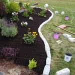 exterior photo of landscaped flower bed with stone perimeter